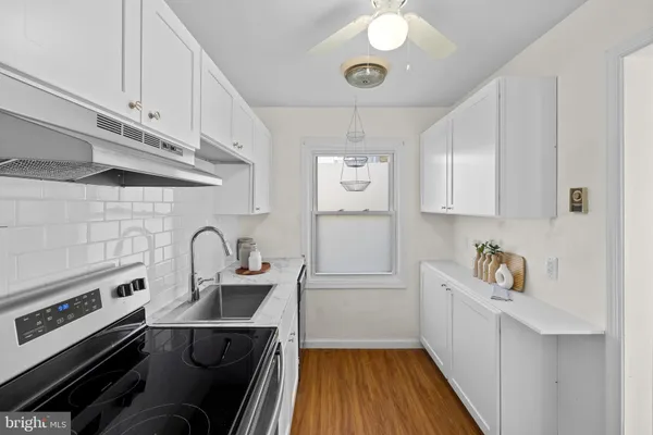 a kitchen with a sink and wooden floor
