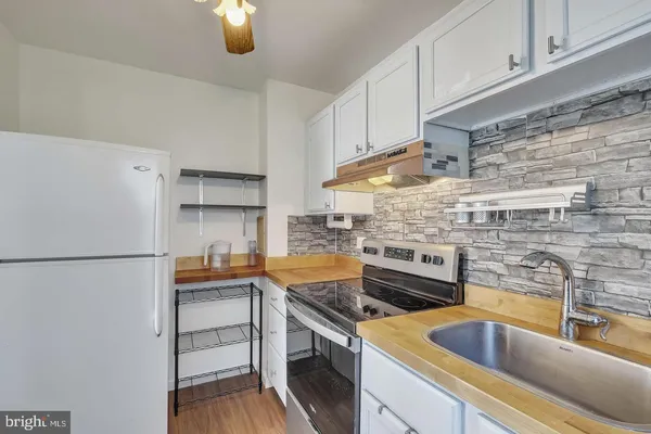 a kitchen with a refrigerator sink and cabinets