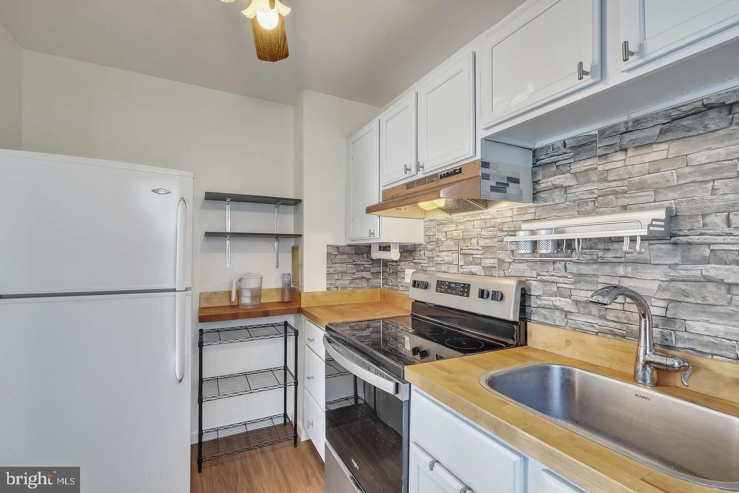 11 Hillside Road Greenbelt, MD 20770 - Photo 18 of 47 a kitchen with a refrigerator sink and cabinets