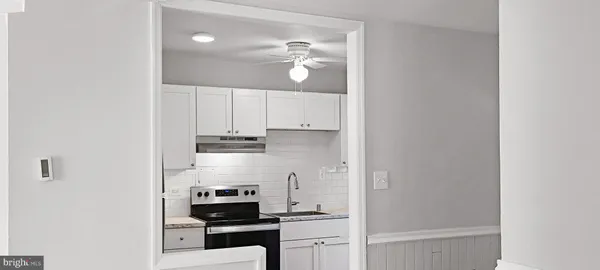 a kitchen with white cabinets and appliances