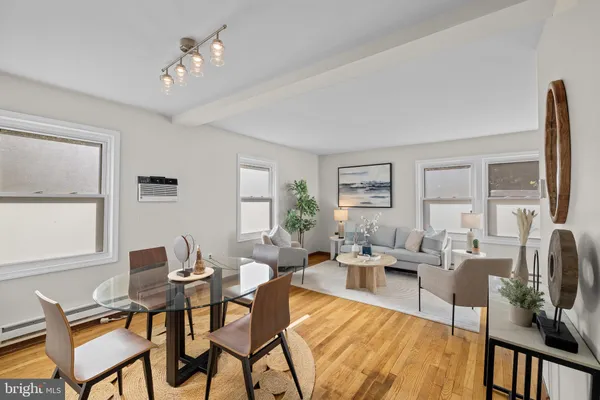 a living room with furniture wooden floor and a large window
