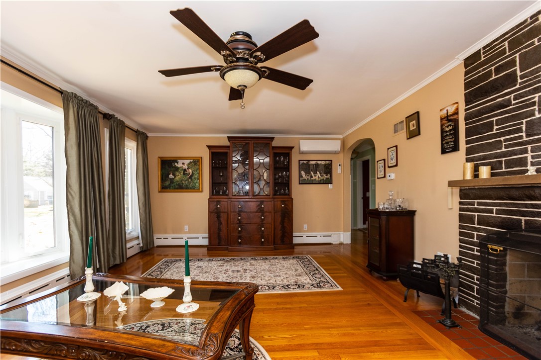 Large Living Room or Formal Dining room with wood fireplace, hardwood floors, large windows including Bay offers lot's of light.