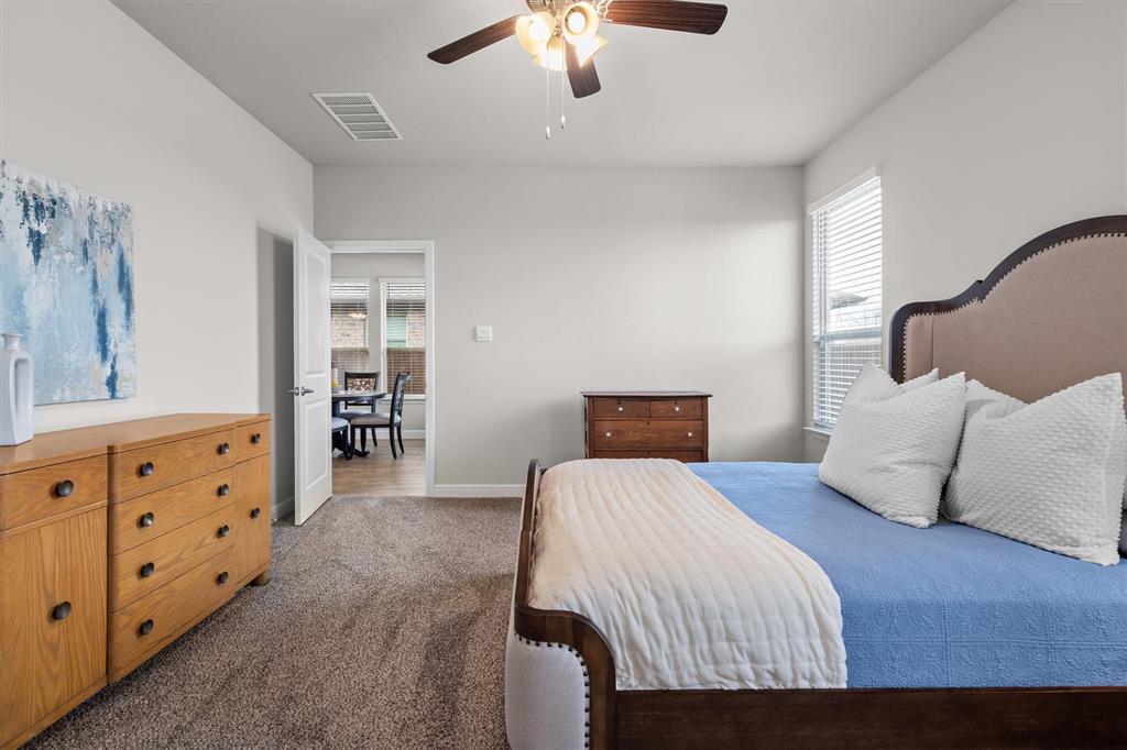 1864 Mensa Drive Haslet, TX 76052 - Photo 26 of 40 a bedroom with a large bed and a chandelier