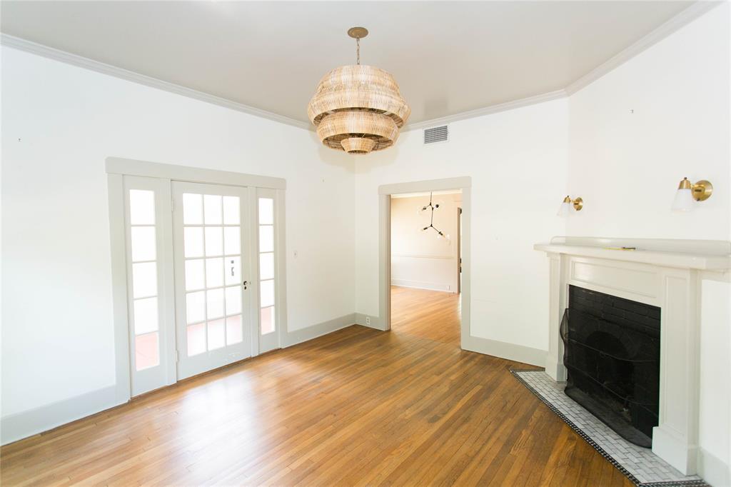 201 West 33rd Street, Unit A Austin, TX 78705 - Photo 2 of 20 a view of an empty room with wooden floor fireplace and a window