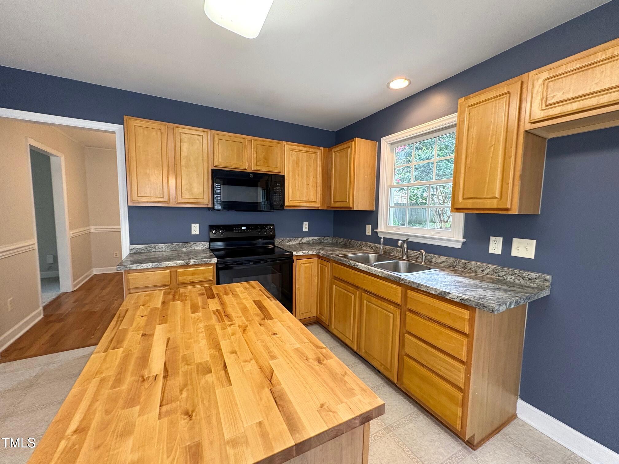 111 Gumdrop Path Apex, NC 27502 - Photo 7 of 17 a kitchen with a sink a counter top space appliances and a window
