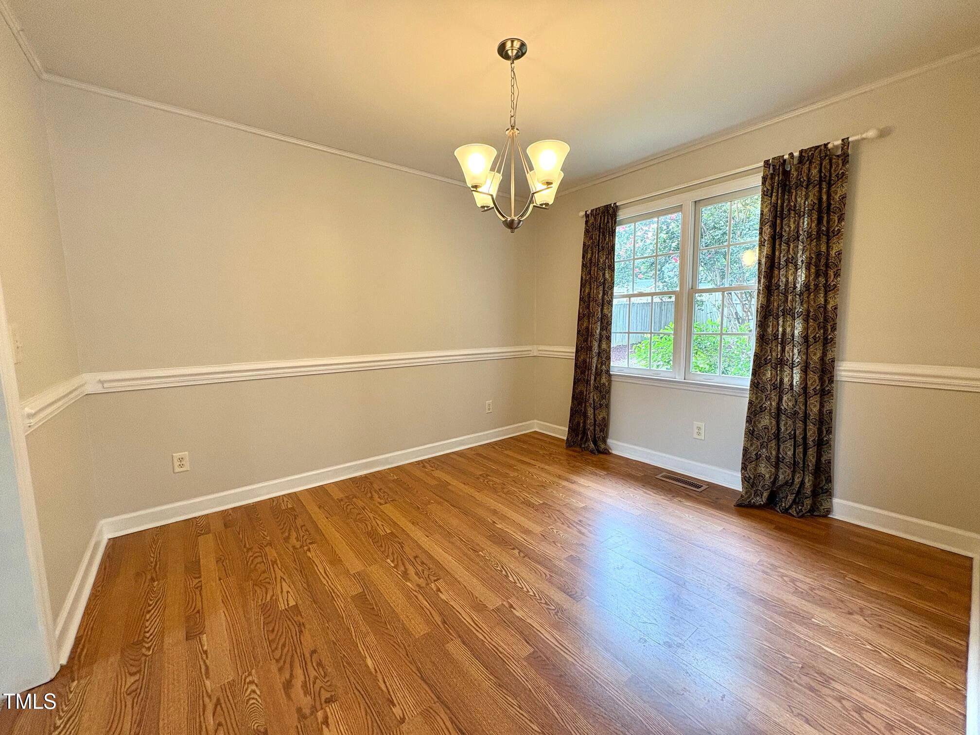 111 Gumdrop Path Apex, NC 27502 - Photo 8 of 17 a view of an empty room with wooden floor and a window