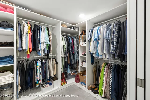 a view of walk in closet with clothes and shoes