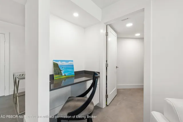 a view of a hallway with workspace and furniture