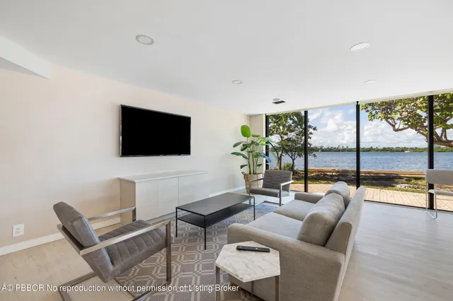 a kitchen with stainless steel appliances granite countertop white cabinets a microwave oven a sink and dishwasher with wooden floor