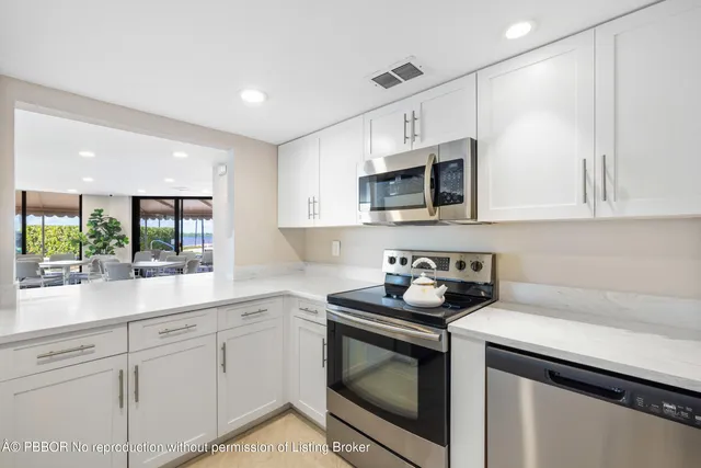 a kitchen with white cabinets stainless steel appliances and sink