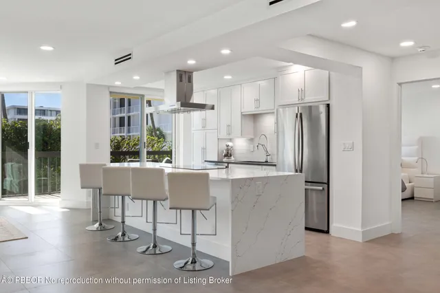 a kitchen with stainless steel appliances kitchen island granite countertop a refrigerator and a stove top oven