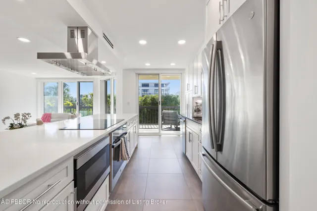 a large kitchen with kitchen island a large window appliances and furniture