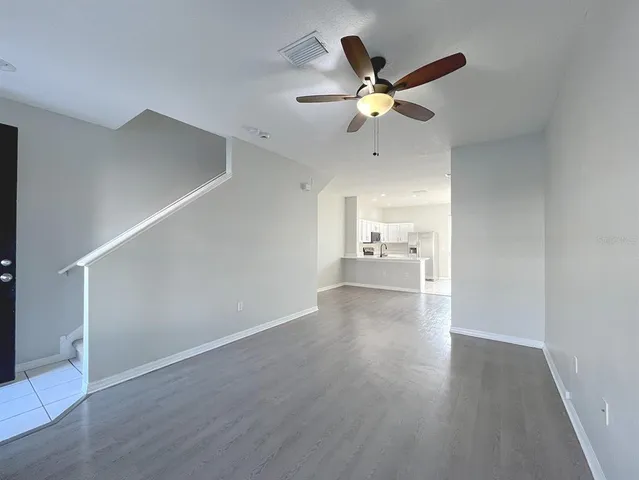 a view of a livingroom with a ceiling fan & wooden floor