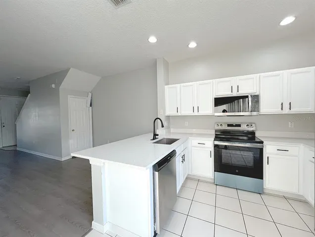 a kitchen with a sink a stove and cabinets
