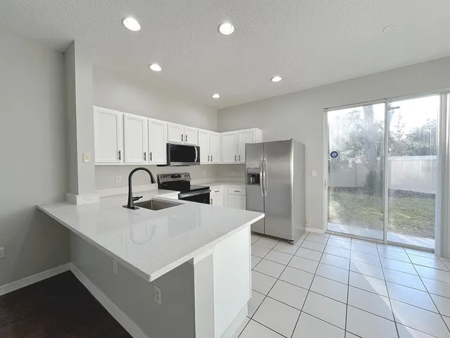 a kitchen with stainless steel appliances a refrigerator sink and cabinets