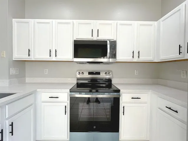 a kitchen with cabinets appliances and a sink
