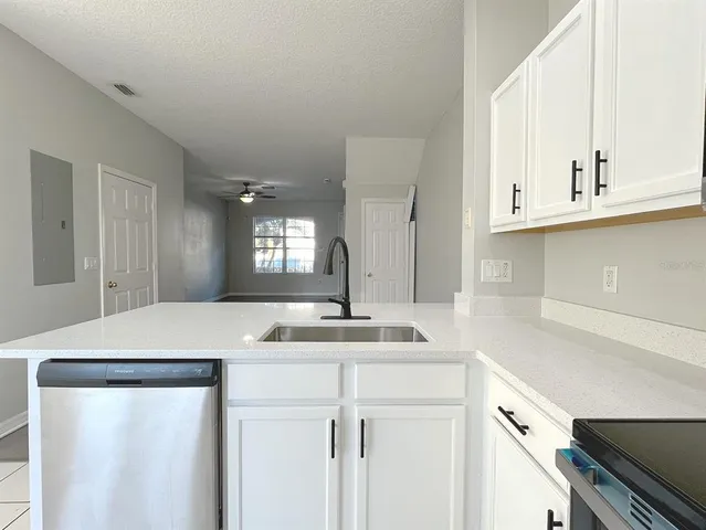 a kitchen with kitchen island a sink and white cabinets