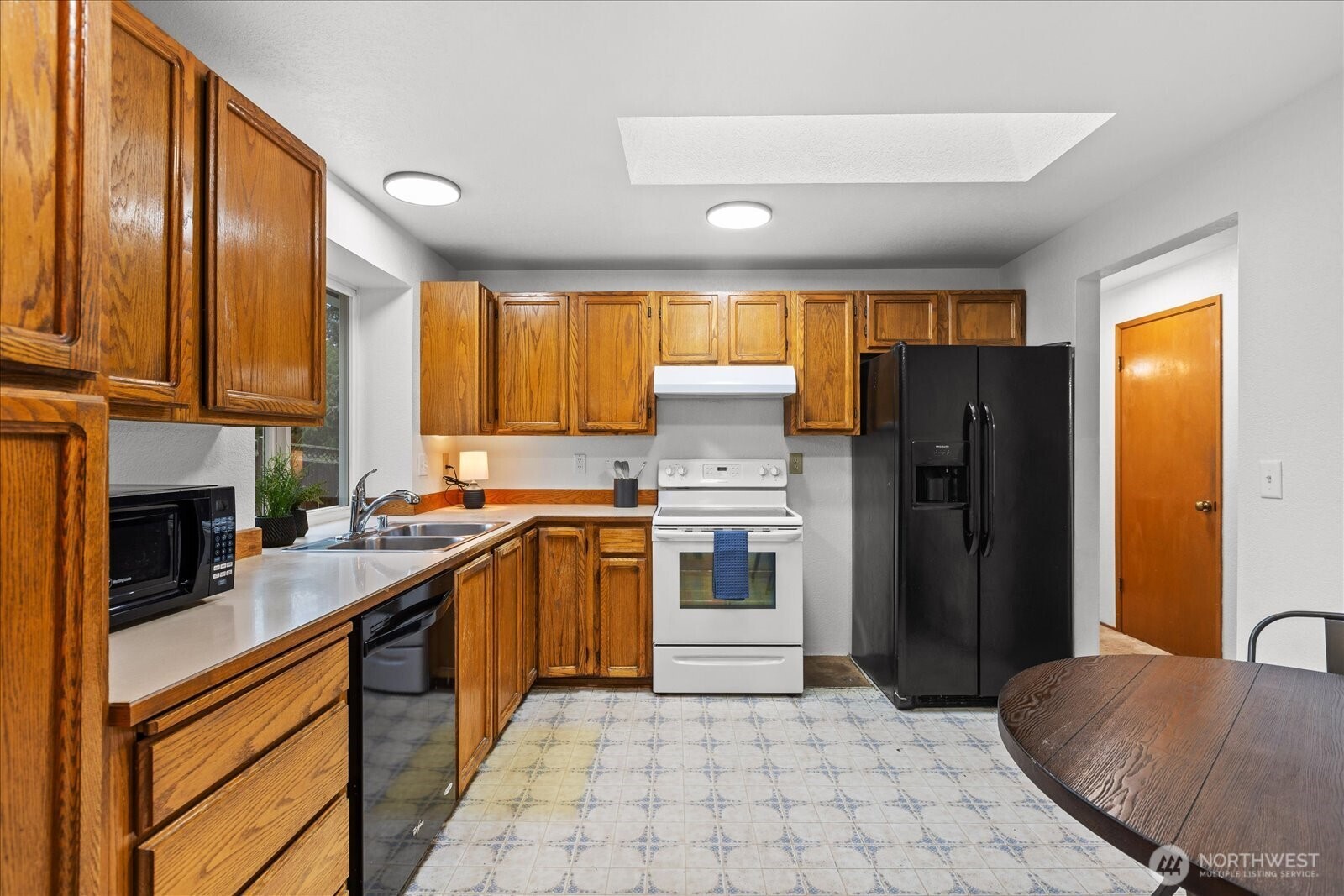 1403 234th Street Southwest Bothell, WA 98021 - Photo 9 of 37 a kitchen with stainless steel appliances granite countertop a refrigerator sink and cabinets