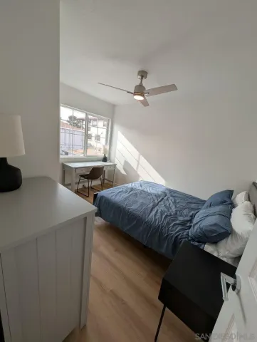 a bedroom with a bed and a ceiling fan