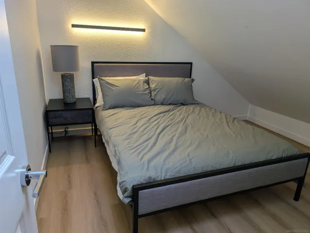 a bedroom with a bed and a night stand