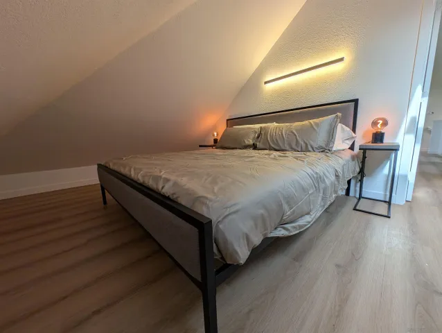 a bed sitting in a bedroom next to a lamp