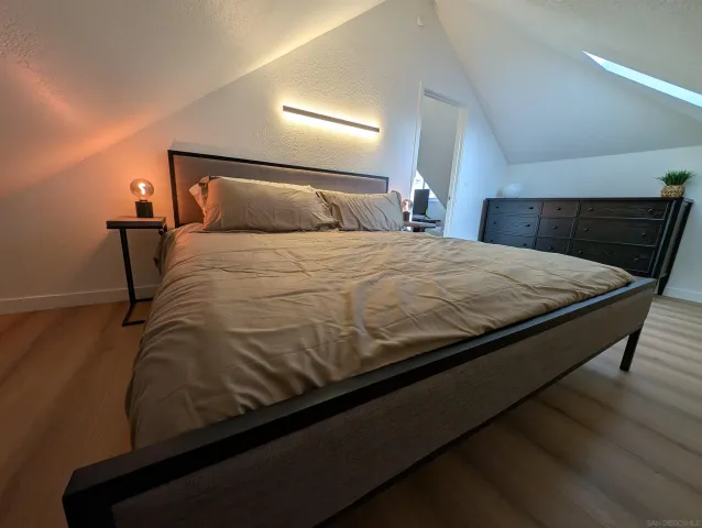 a bedroom with a bed and wooden floor