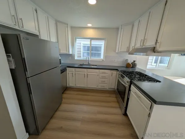 a kitchen with granite countertop stainless steel appliances a refrigerator a sink a stove a microwave and cabinets