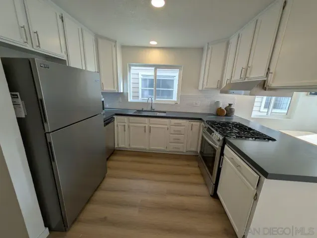 a kitchen with granite countertop stainless steel appliances a refrigerator a sink a stove a microwave and cabinets