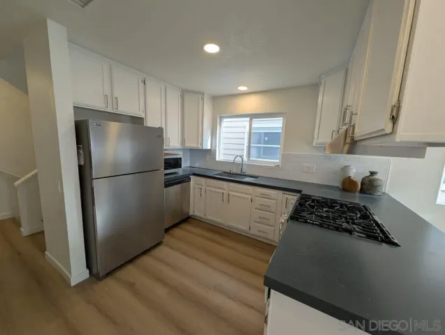 a kitchen with a refrigerator a sink and cabinets