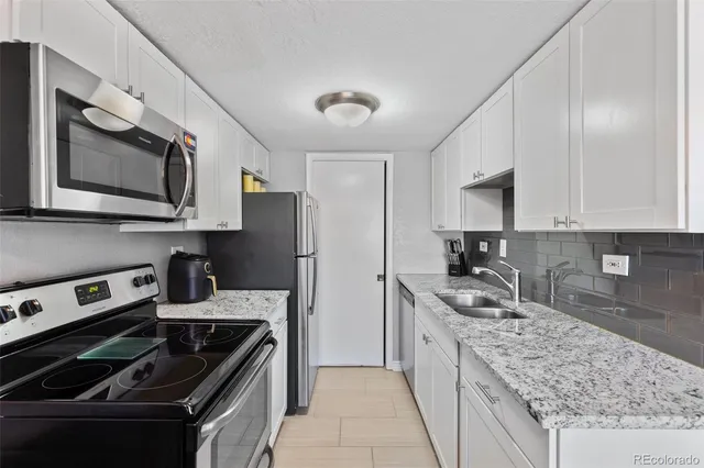 a kitchen with stainless steel appliances granite countertop a sink stove microwave and cabinets