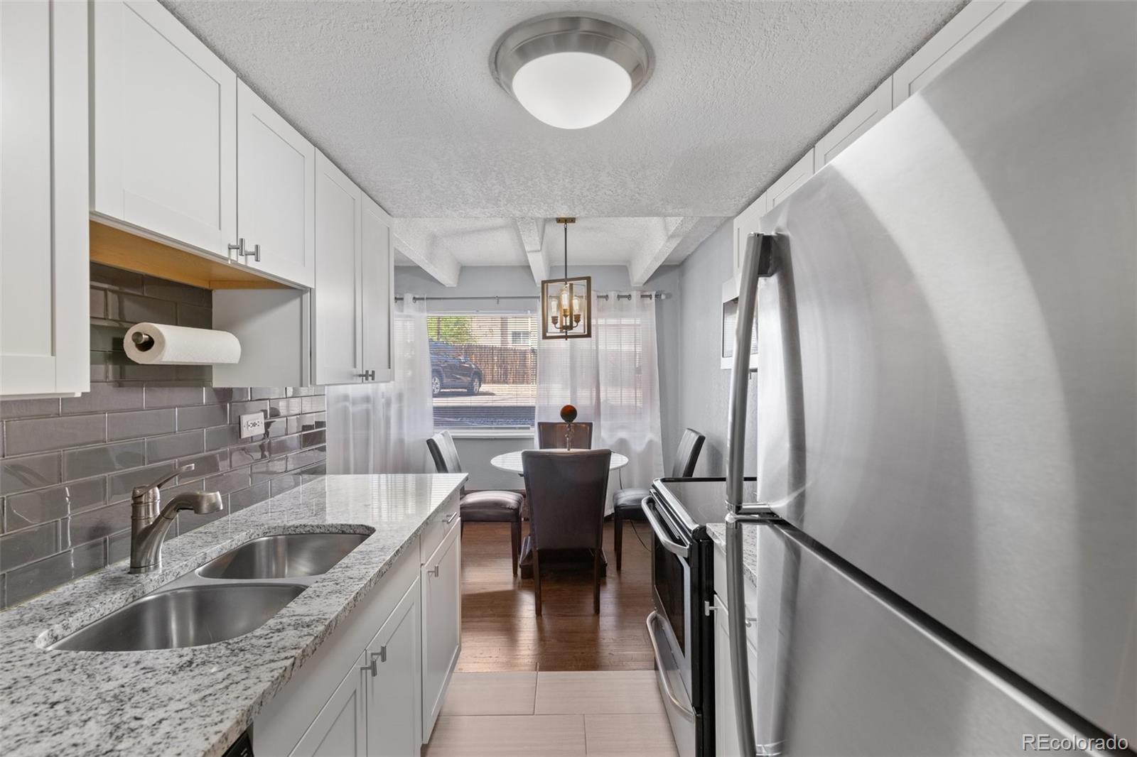 200 Pearl Street, Unit 106 Denver, CO 80203 - Photo 3 of 16 a kitchen with sink cabinets and refrigerator