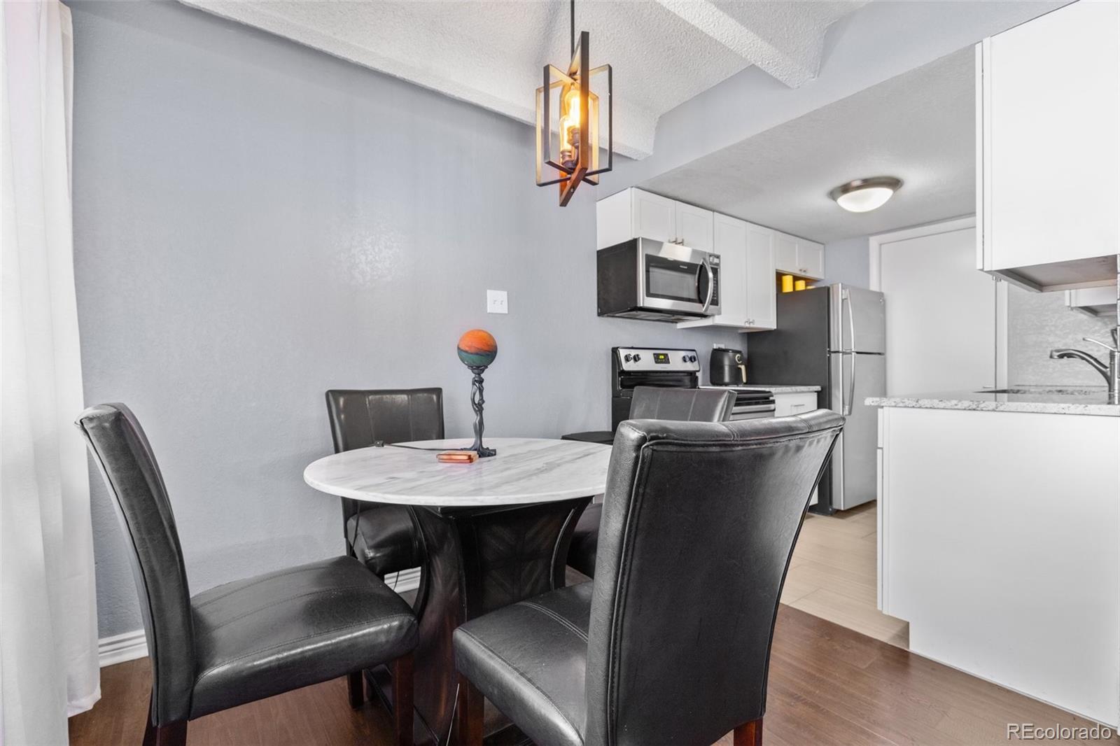 200 Pearl Street, Unit 106 Denver, CO 80203 - Photo 4 of 16 a view of a dining room with furniture and a chandelier