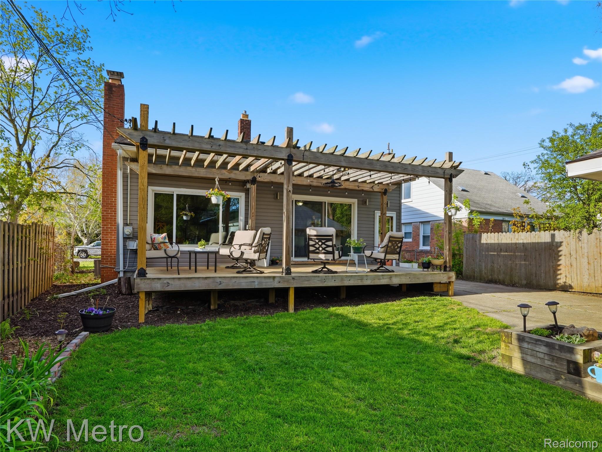 1861 Harvard Road Berkley, MI 48072 - Photo 22 of 27 Back of property featuring a fenced backyard, a deck, and a pergola