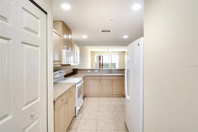 a kitchen with white cabinets and appliances