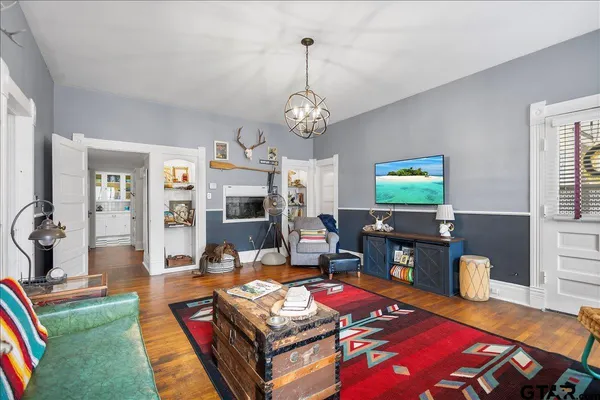 a living room with furniture a window and wooden floor