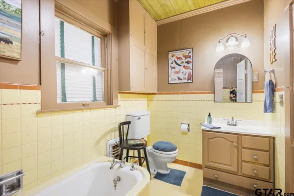 a spacious bedroom with a bed a couch and a chandelier