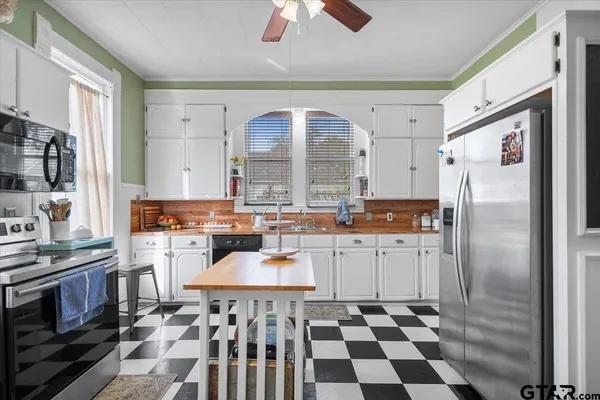 a view of a house with a yard and large tree