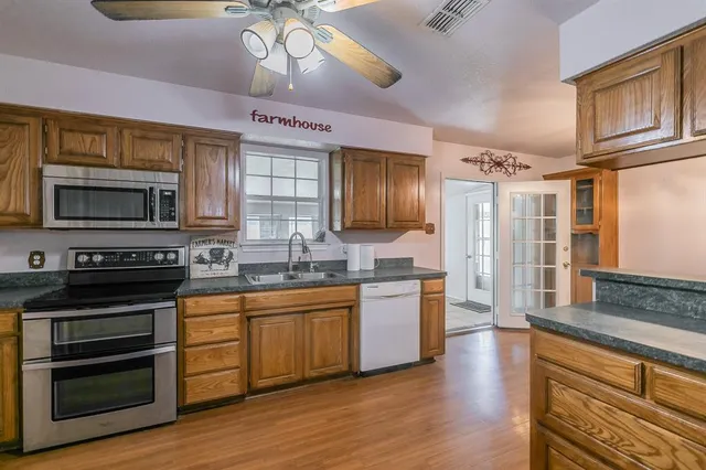 a large kitchen with stainless steel appliances granite countertop a stove and a sink