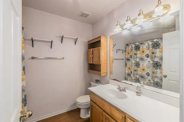 a bathroom with a sink vanity granite and toilet