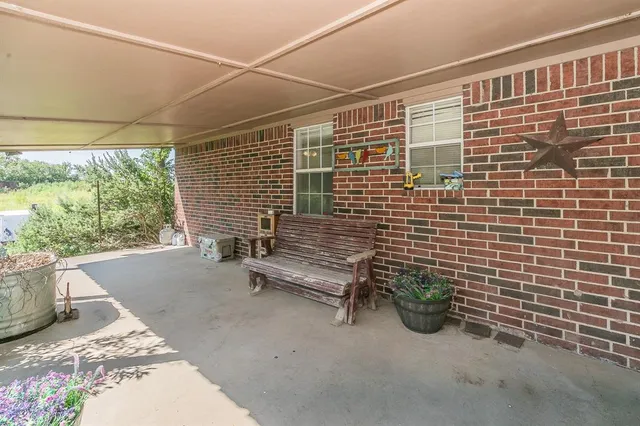 a view of a patio with table and chairs and potted plants