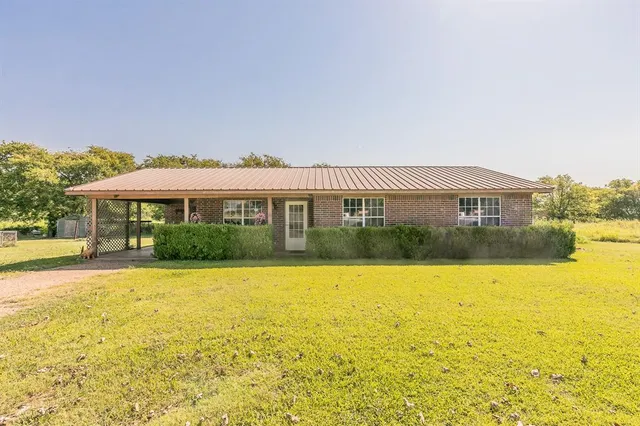 a front view of house with yard and swimming pool