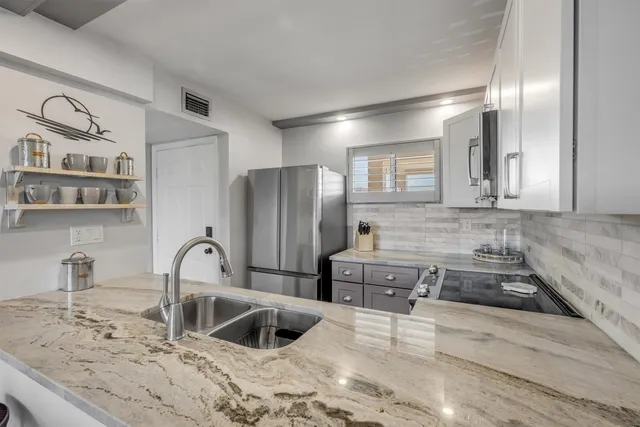 a kitchen with a refrigerator sink and cabinets