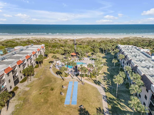 a view of swimming pool with outdoor seating and palm trees