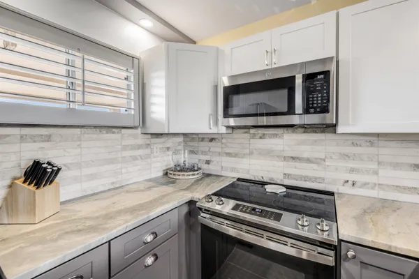 a kitchen with granite countertop a stove microwave and sink