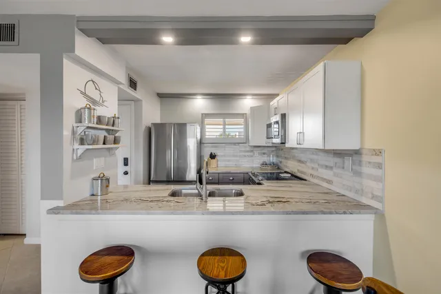 a bathroom with a granite countertop sink and a large mirror