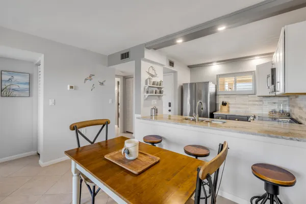 a view of a dining room with furniture and a kitchen