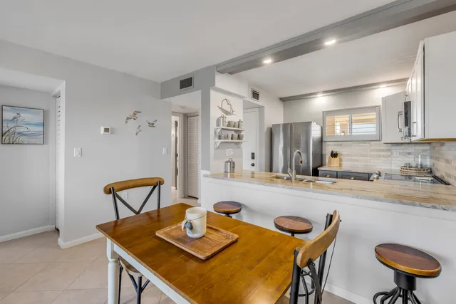 a view of a dining room with furniture and a kitchen