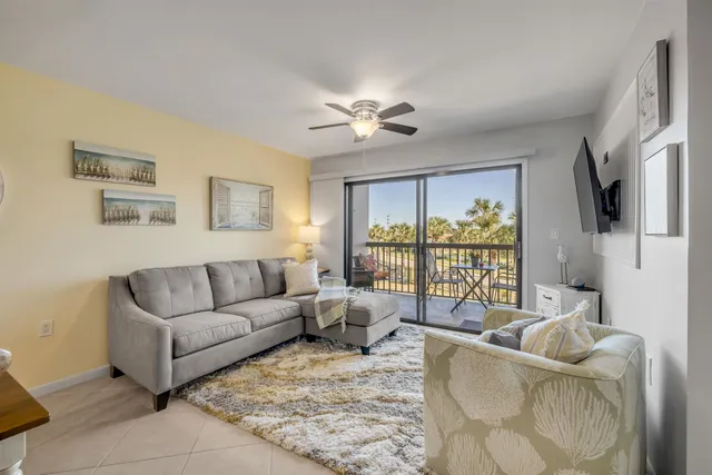 a living room with furniture and a floor to ceiling window