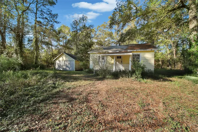 a front view of house with yard and trees around