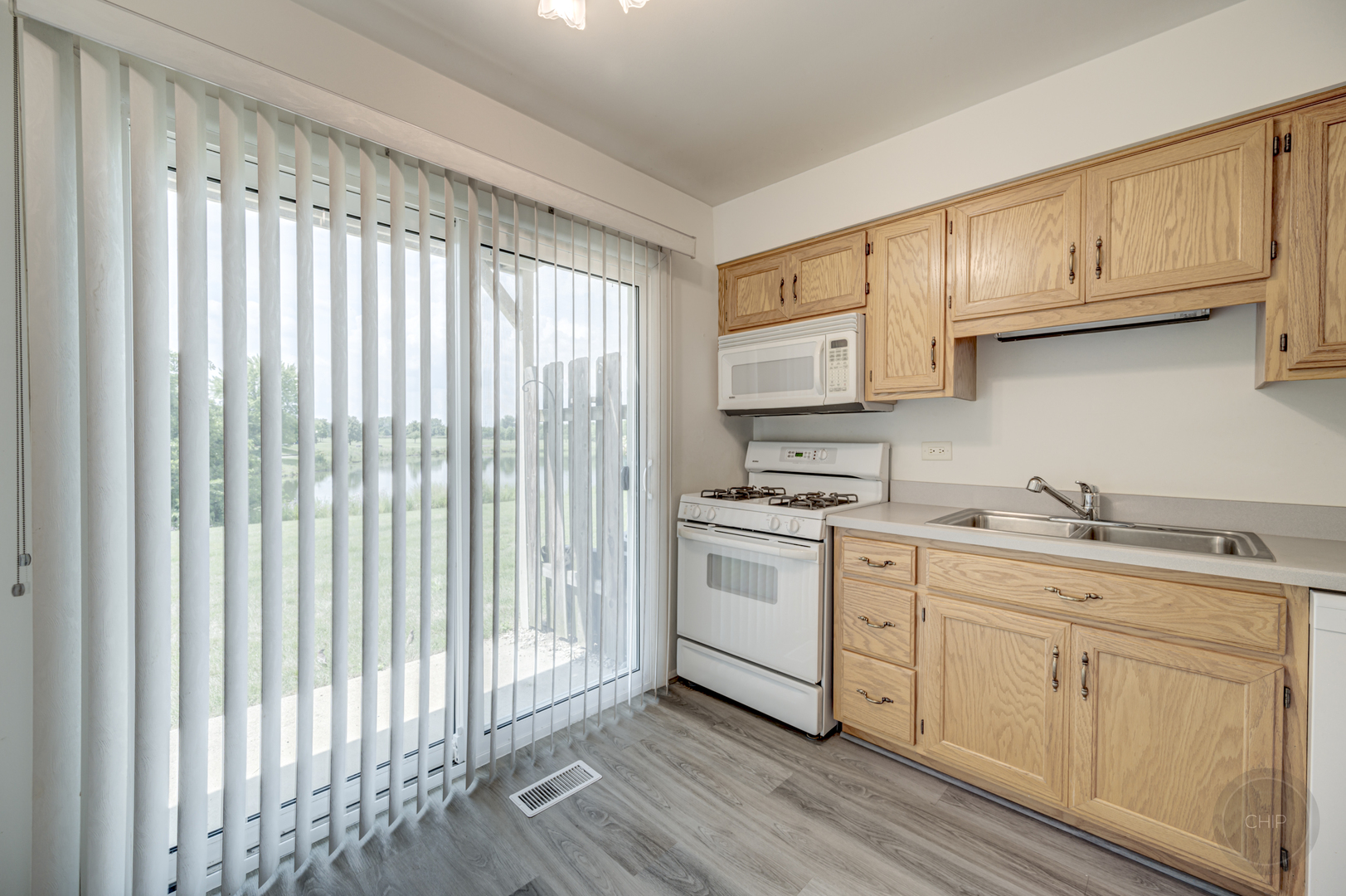 360 Springlake Lane, Unit B Aurora, IL 60504 - Photo 11 of 26 a kitchen with granite countertop white cabinets and white appliances
